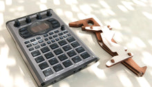 An SP-404 next to an instrument stand.