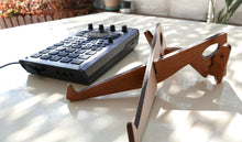An SP-404 MK2 next to an instrument stand.