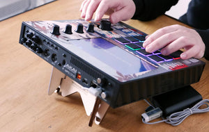 A pair of hands playing an Akai MPC One