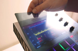 A pair of hands placing a skin on an Akai MPC One