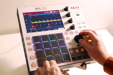 A pair of hands playing an Akai MPC One